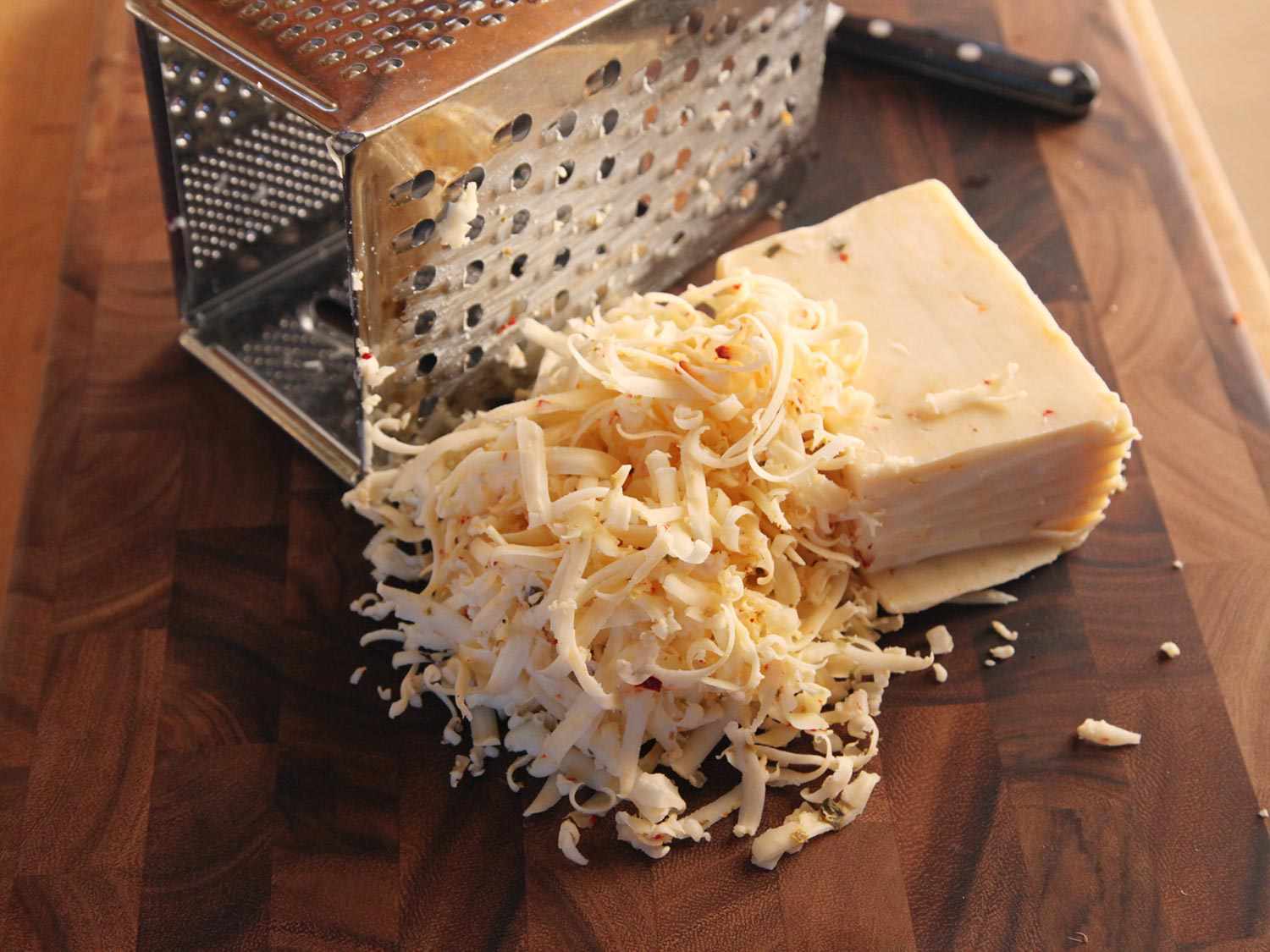 Block of Pepper Jack cheese shredded with a boxer grater.