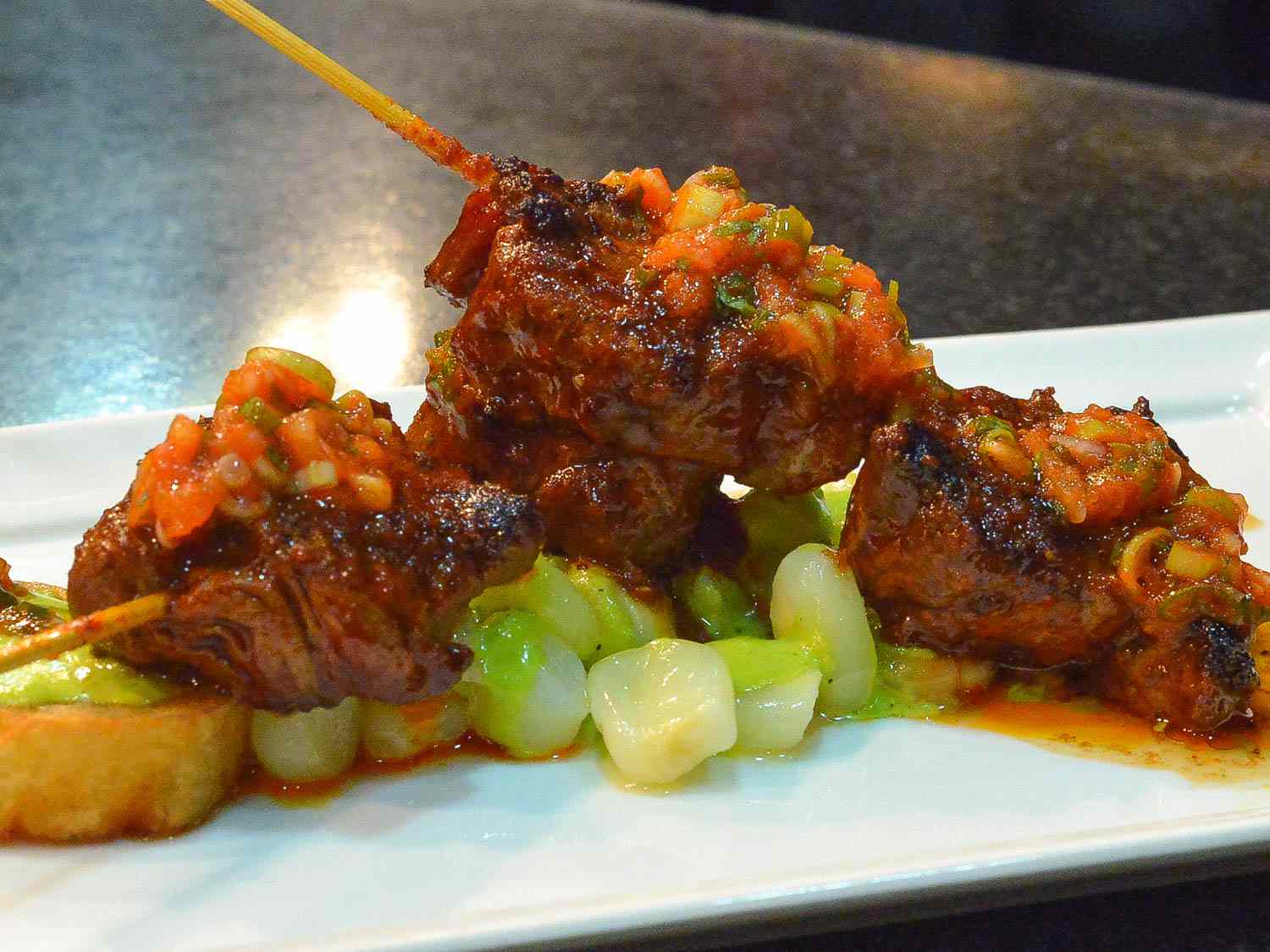 Anticucho de Corazón (grilled heart) on skewers with vegetables.