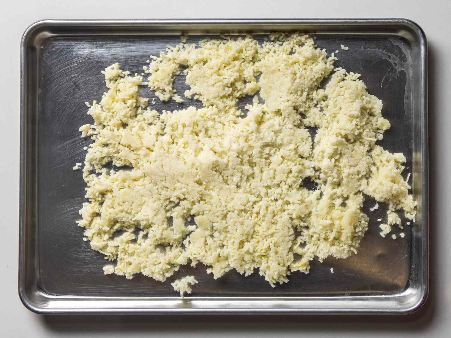 riced potatoes on rimmed baking sheet