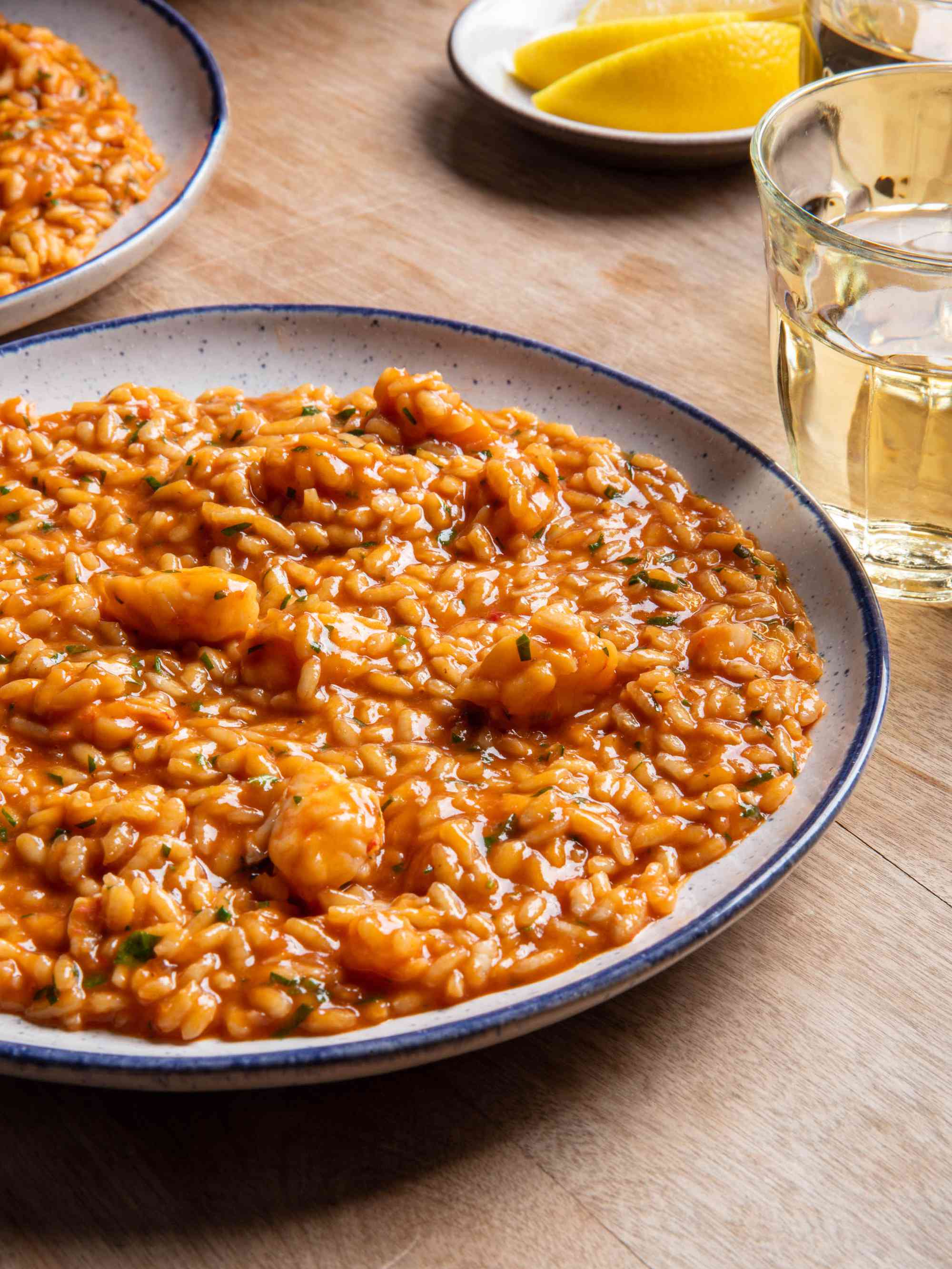 Shrimp risotto fills a blue-rimmed white bowl.
