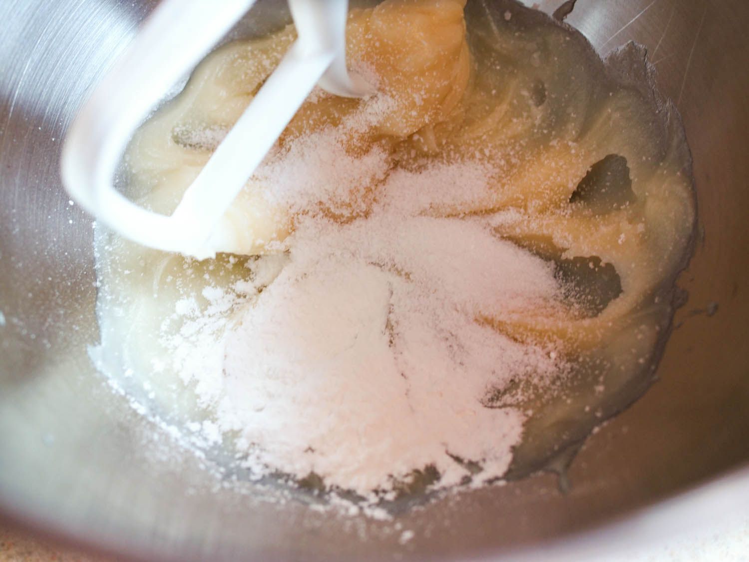Lard, salt, and baking powder being combined in a stand mixer fitted with the beater attachment.
