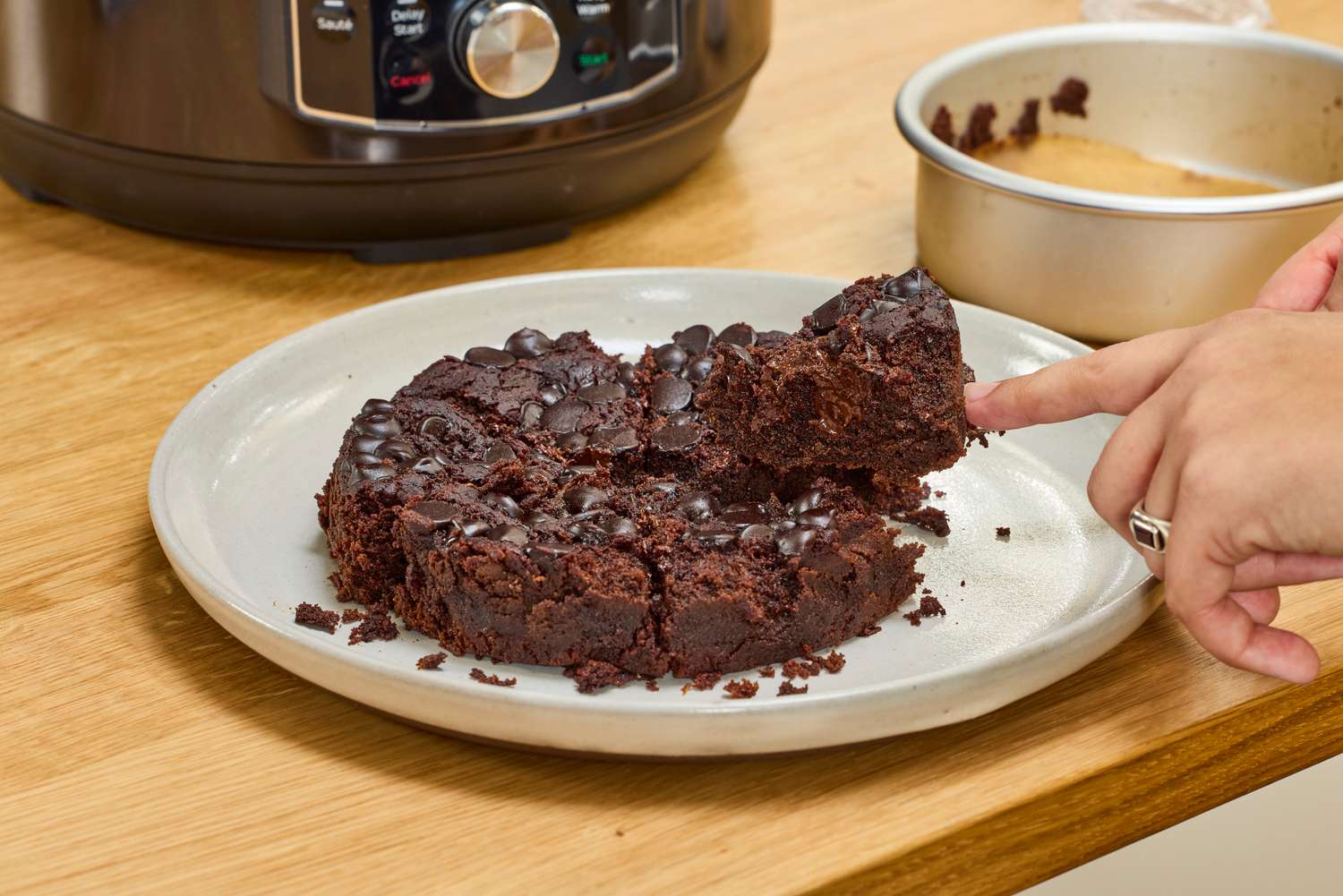 A person cuts a cake baked in the Instant Pot Pro 10-in-1 6-Quart Pressure Cooker