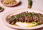 Sliced steak topped with green chermoula served with chickpea salad on the side