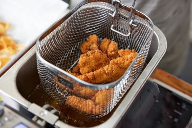 Fried chicken tenders in a deep-fryer basket