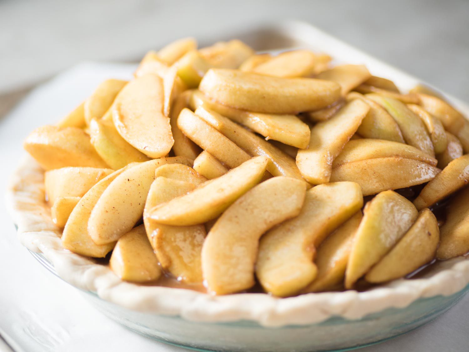 A pie crust filled with apple pie filling. 
