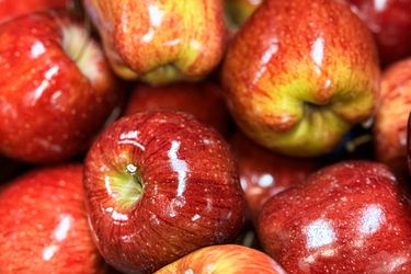 A collection of shiny red apples piled together