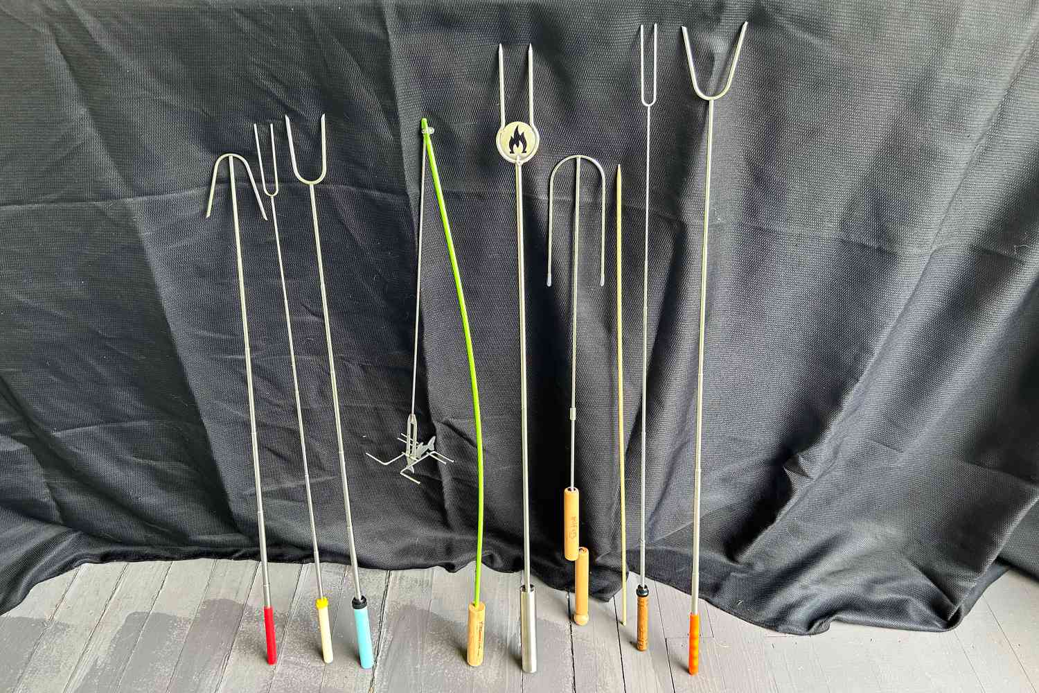 Numerous marshmallow roasting sticks side-by-side.