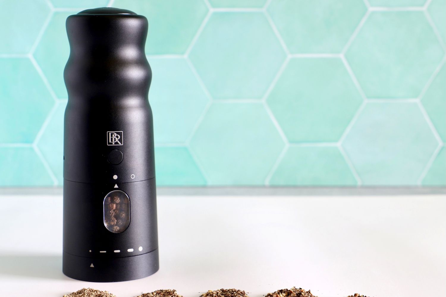 the black rain pepper mill with different sizes of ground pepper