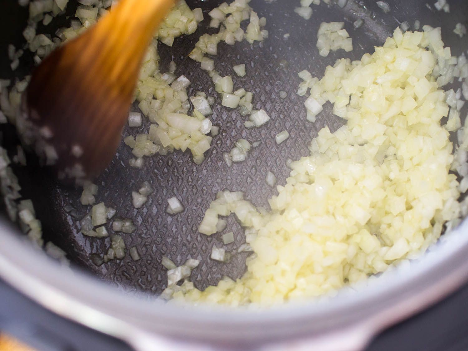 Sweating finely diced onion in a pressure cooker. 