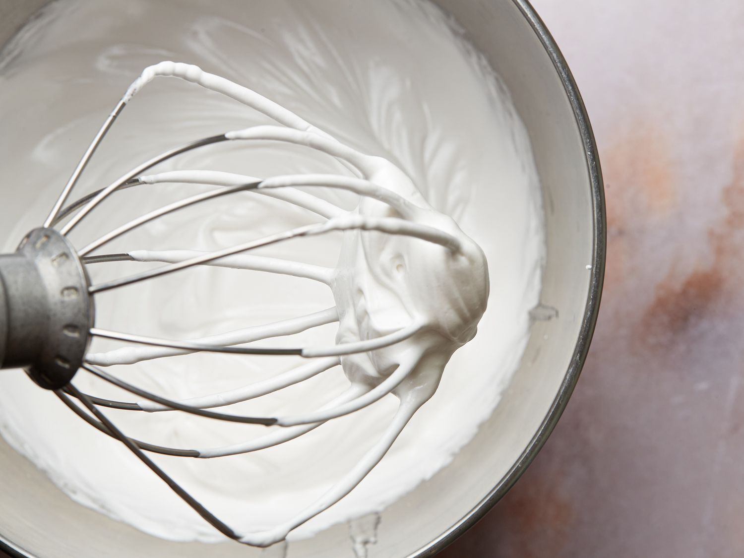Meringue after mixed with sugar and stiff peaks have formed on whisk
