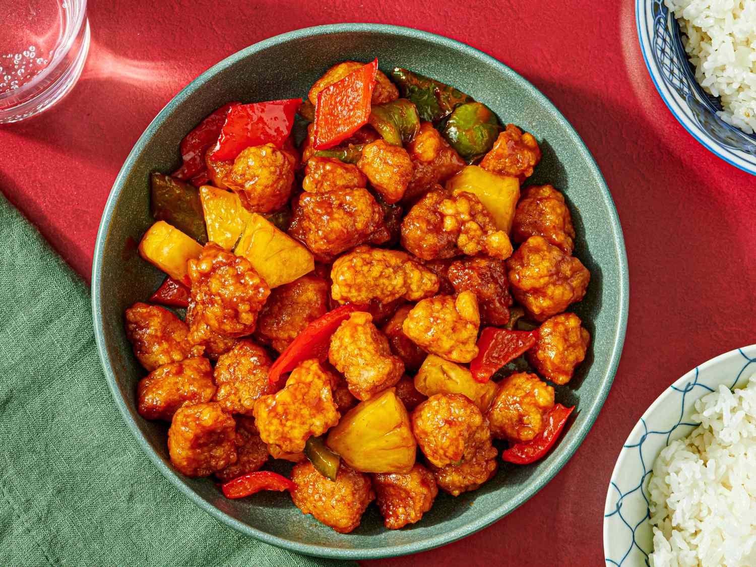 A dish of sweet and sour pork served in a bowl with rice on the side