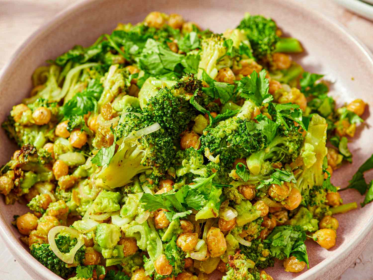 A dish featuring broccoli chickpeas and fresh herbs served in a bowl