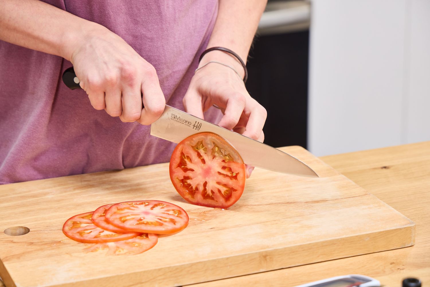 A person slices tomato using the Misono 8.2 Inch Molybdenum Gyutou