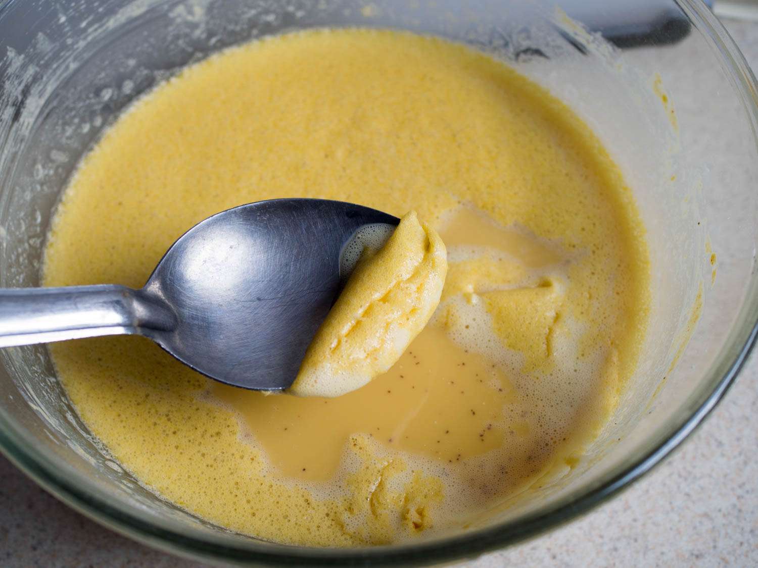 Scooping off foams on the surface of a farinata batter. 