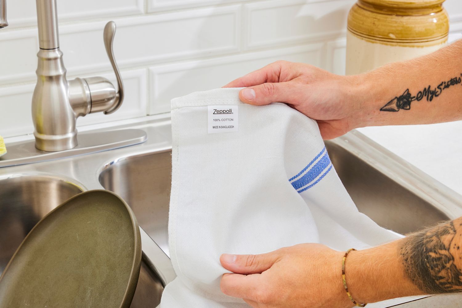 A person holding a Zeppoli kitchen towel.