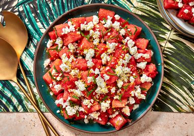 Watermelon, feta, and mint salad in a bowl on a colorful tropical print napkin.