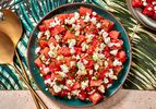 Watermelon, feta, and mint salad in a bowl on a colorful tropical print napkin.