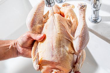 Overhead view of washing a chicken in the sink 
