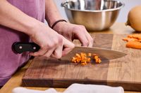 A person cuts carrots using the Wüsthof Classic 8-Inch Chef's Knife