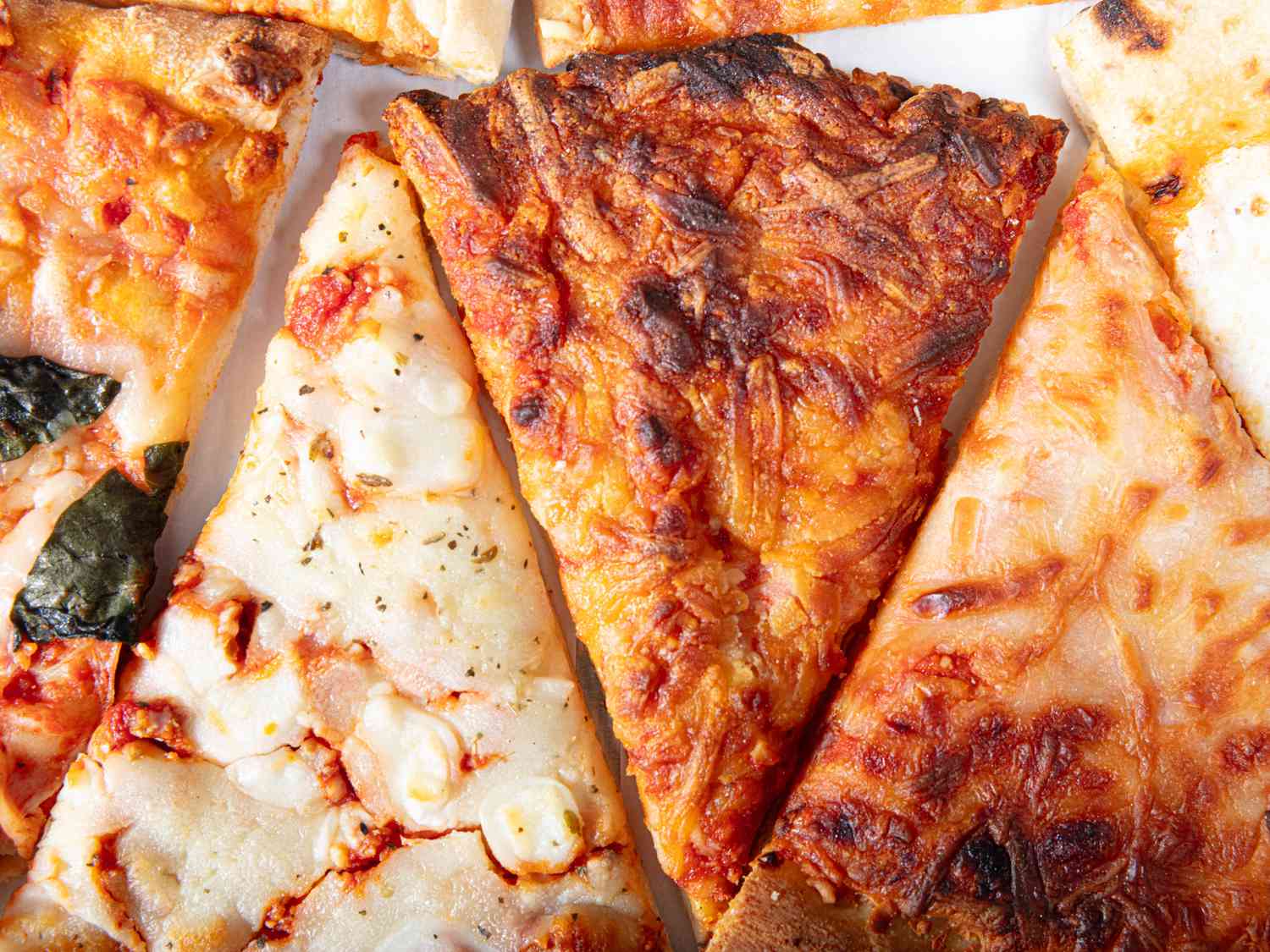 Close up of different frozen pizzas arranged in a zig zag 