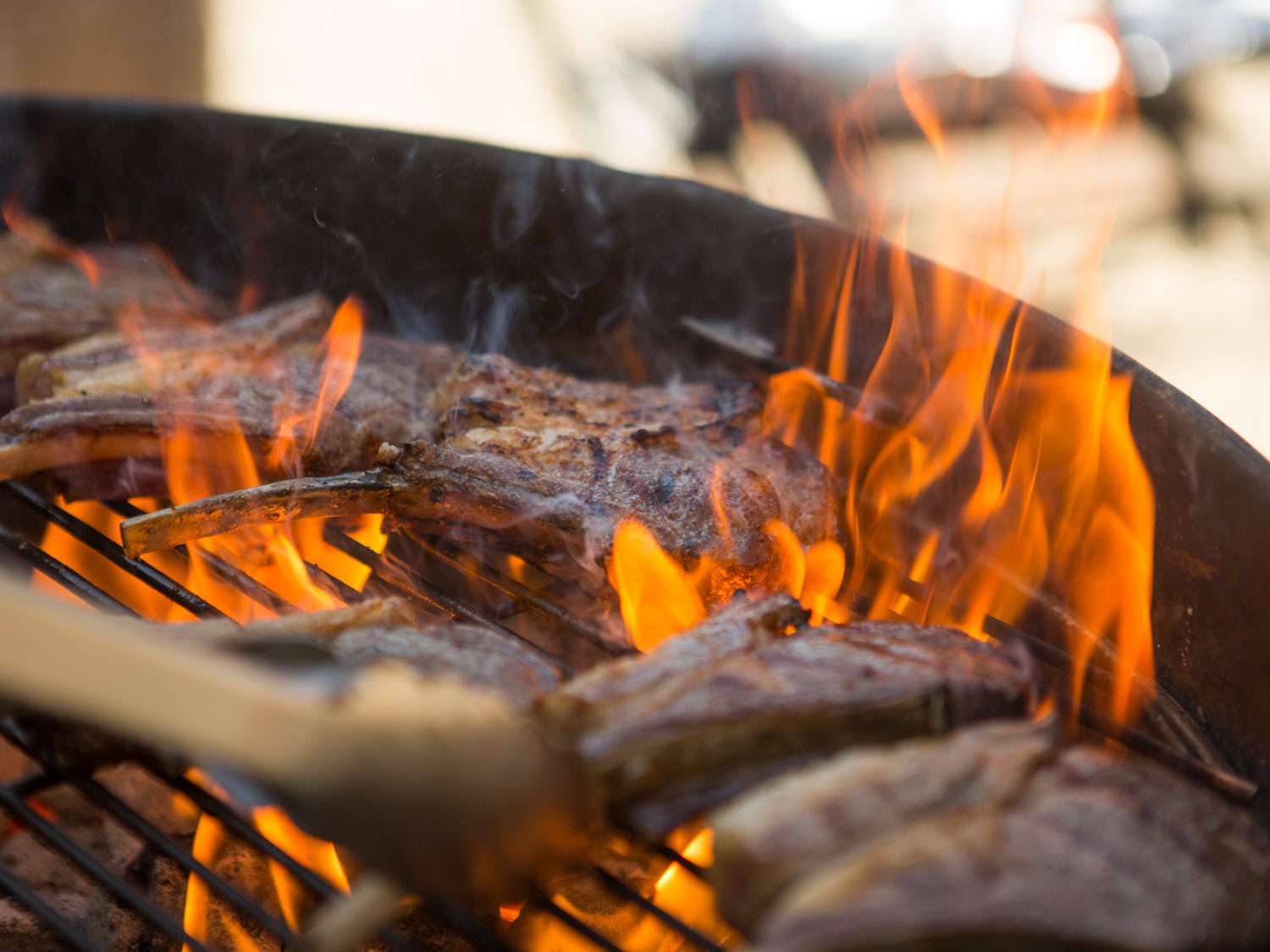 Lamb chops on a grill during a flare-up.