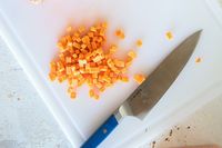 Diced food and a Misen knife on a cutting board