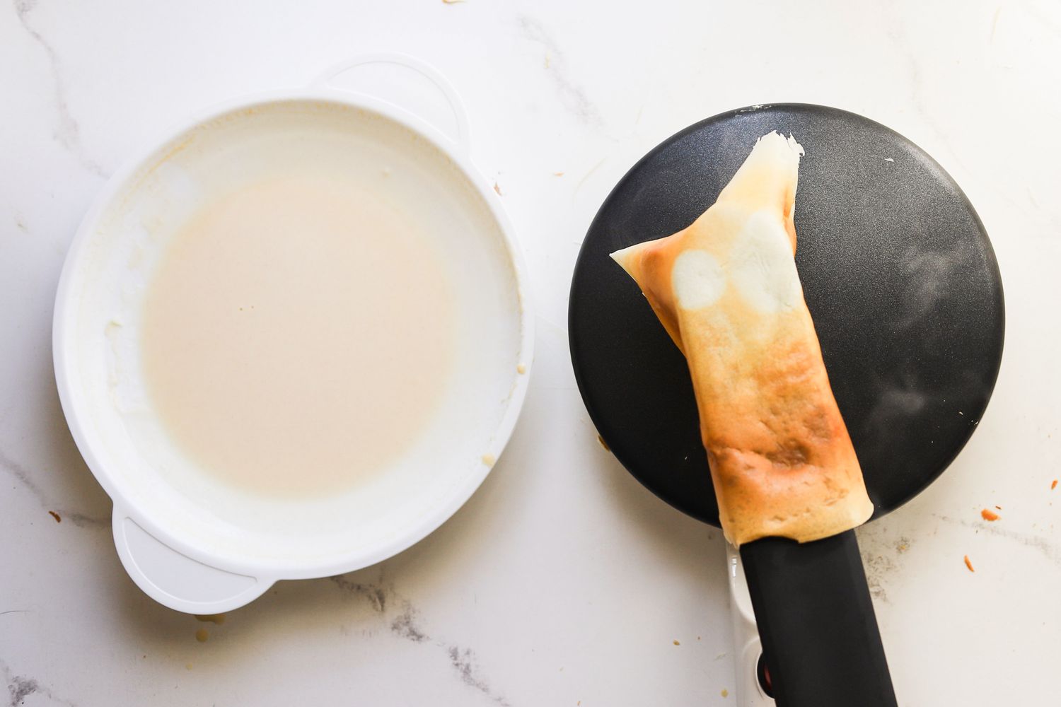 a person flipping a crepe on a crepe maker
