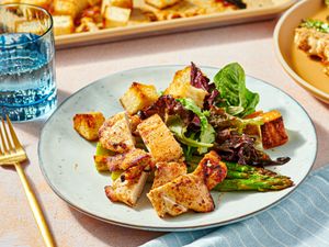 Plated honey mustard chicken thighs with roasted vegetables and greens