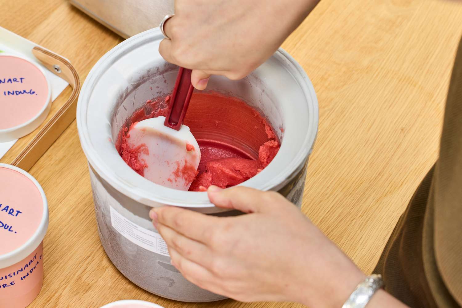 A person using a spatula in ice cream made in the Cuisinart Pure Indulgence 2 Quart Frozen Yogurt-Sorbet & Ice Cream Maker ICE-30BCP1