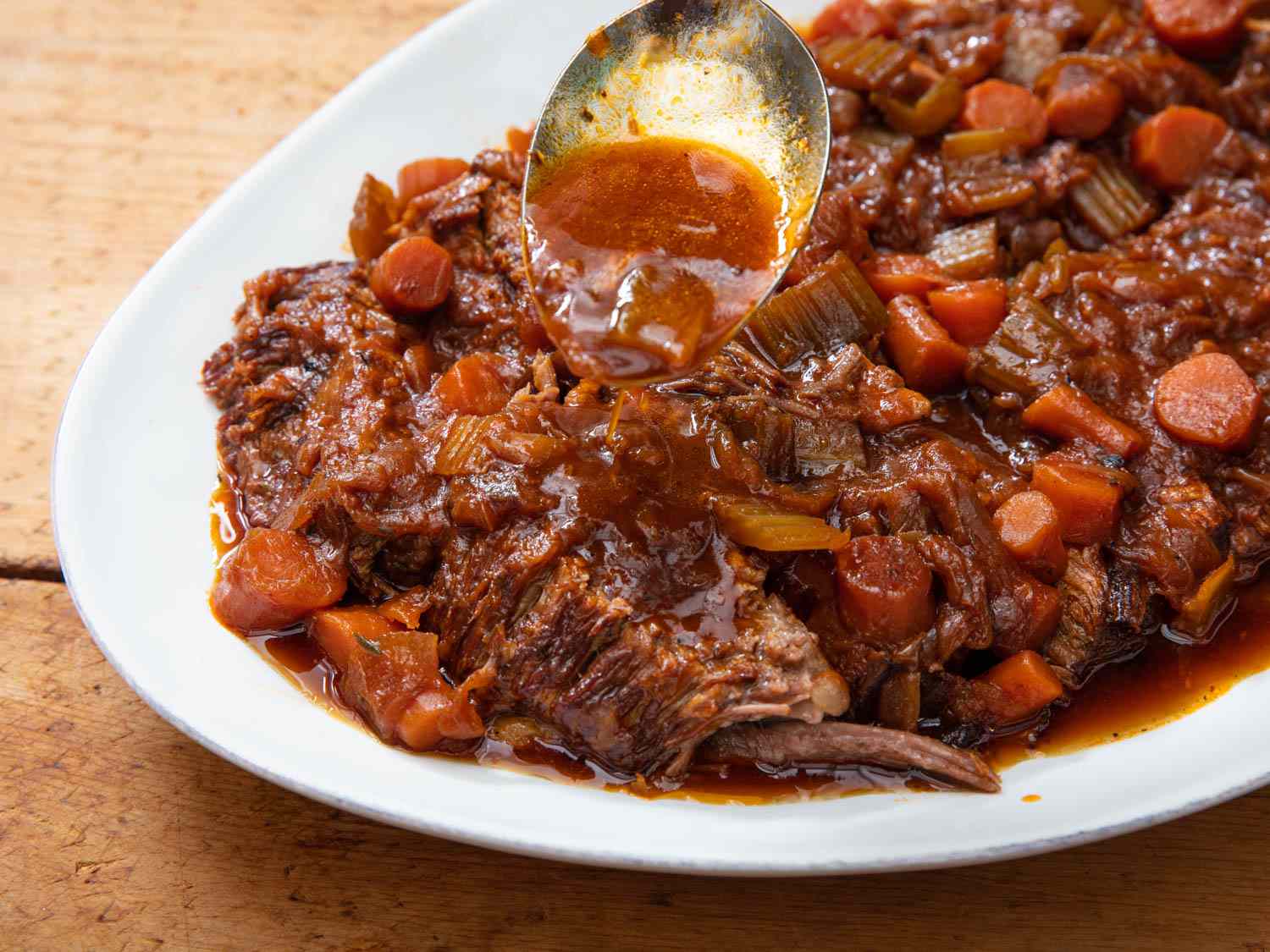 Closeup of the brisket being served on a white oval platter.