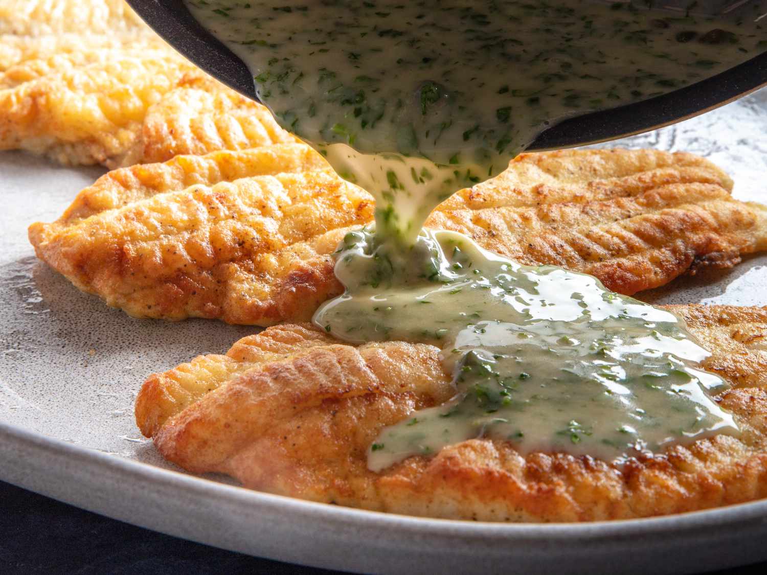 The sauce being poured on the fish for serving: The sauce is very creamy and homogenous, perfectly emulsified and not at all broken.