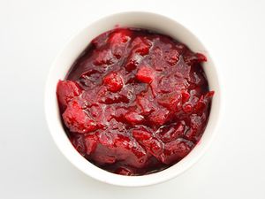 Overhead closeup of Apple-Orange Cranberry Sauce, served in a white ramekin.