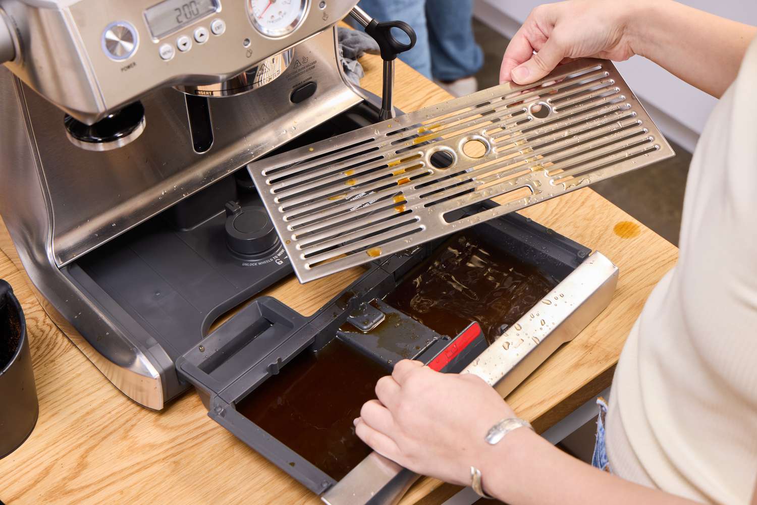 A person disassembles the Breville BES920XL Dual Boiler Espresso Machine