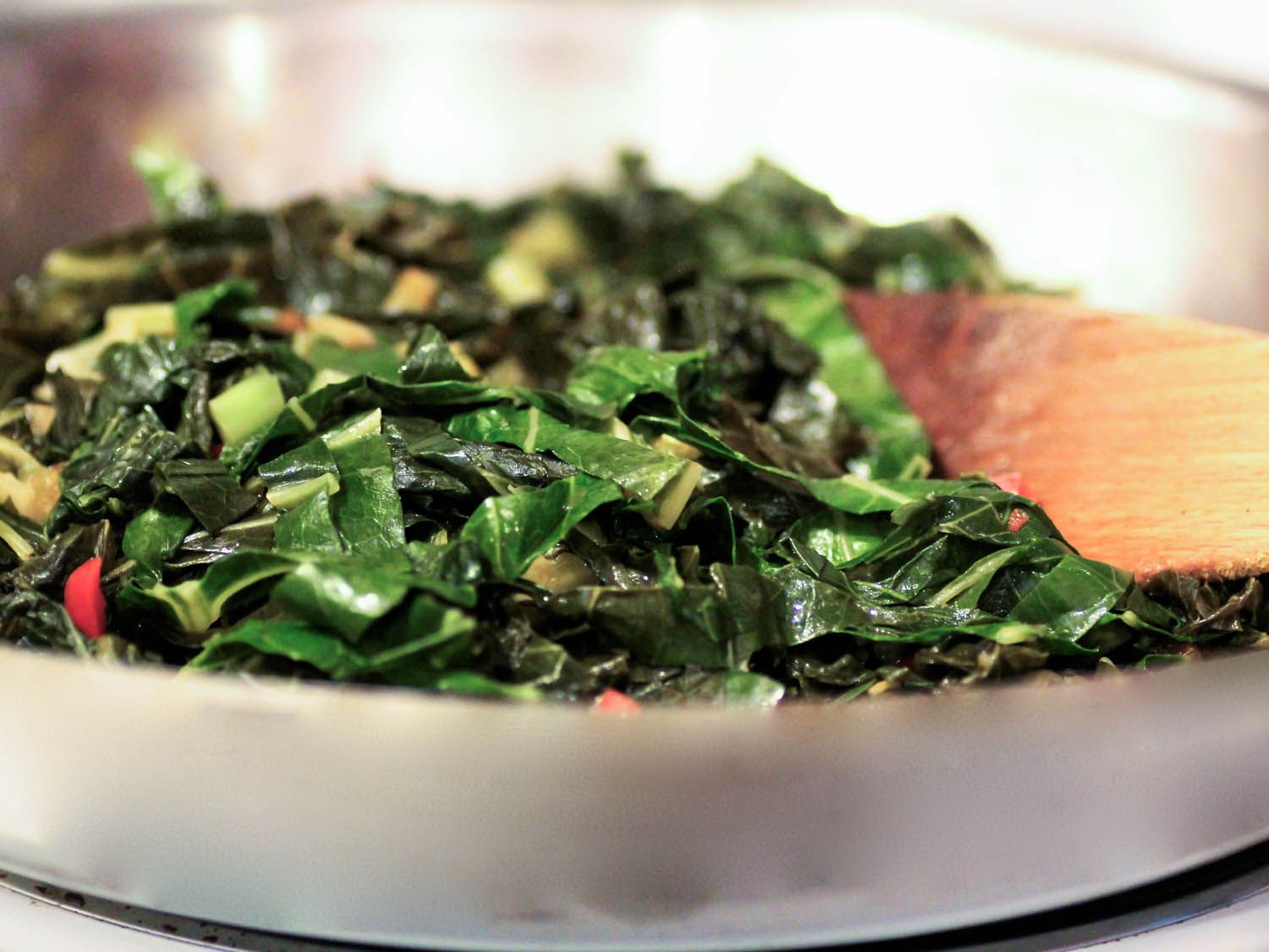 Shredded collards cooking in a skillet.