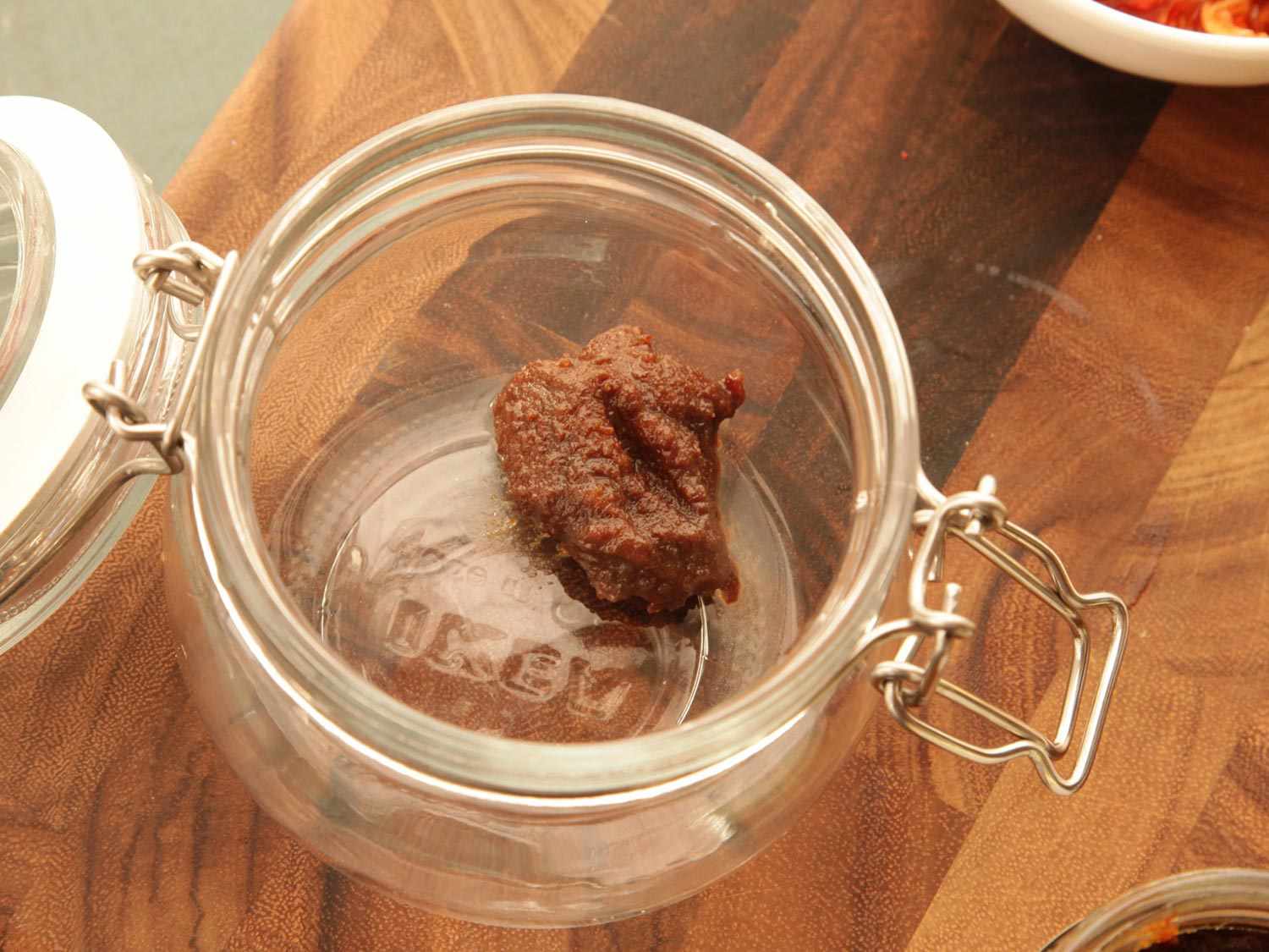 A cliptop jar with a spoonful of Better than Bouillion brand beef broth base.