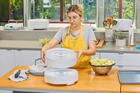 A person holding Nesco Snackmaster Pro Food Dehydrator