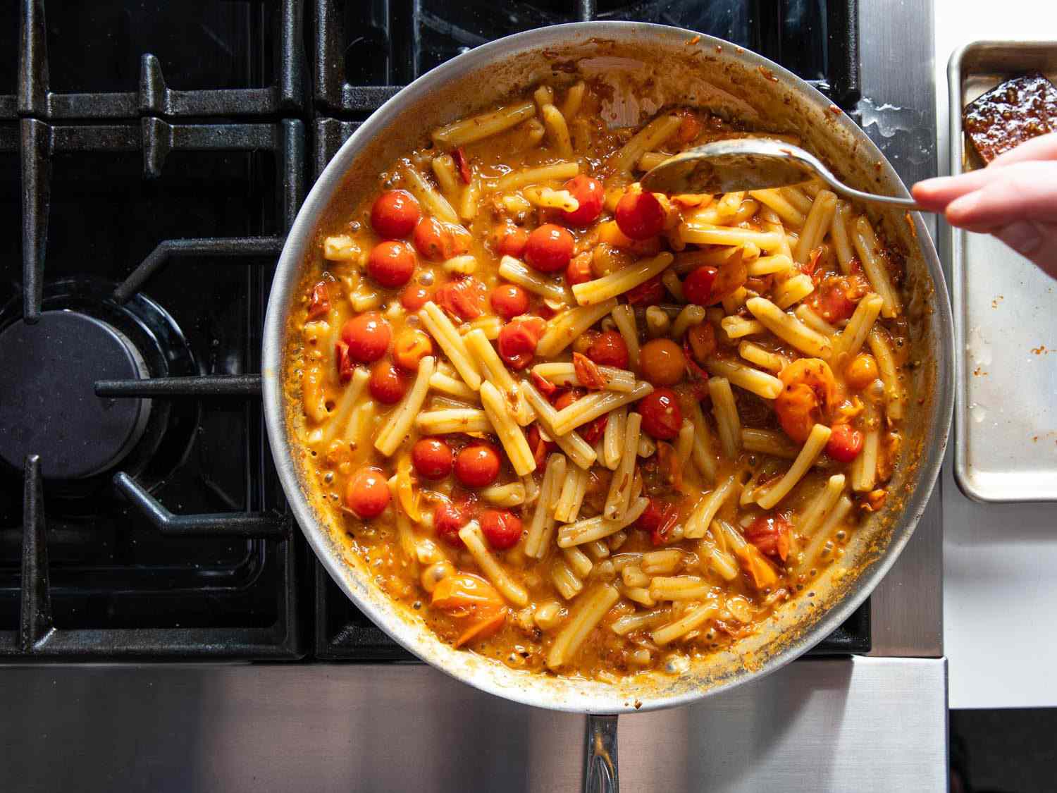 Finishing pasta in the skillet by emulsifying starchy pasta water into a creamy sauce with burst cherry tomatoes and XO sauce.