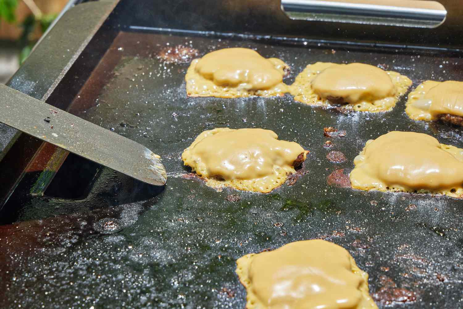 A cheeseburger is cooked on the Traeger Flatrock Flat Top Grill