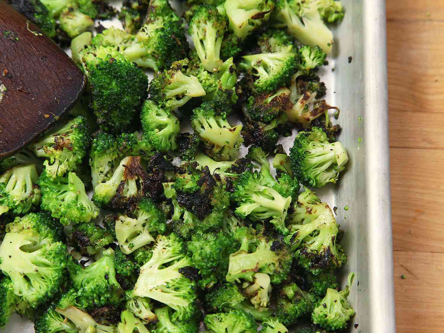 Cooling charred broccoli florets in a baking sheet. 
