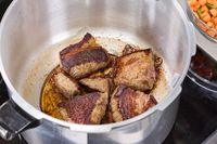 Beef chunks are seared in the Presto 16-Quart Pressure Canner and Cooker