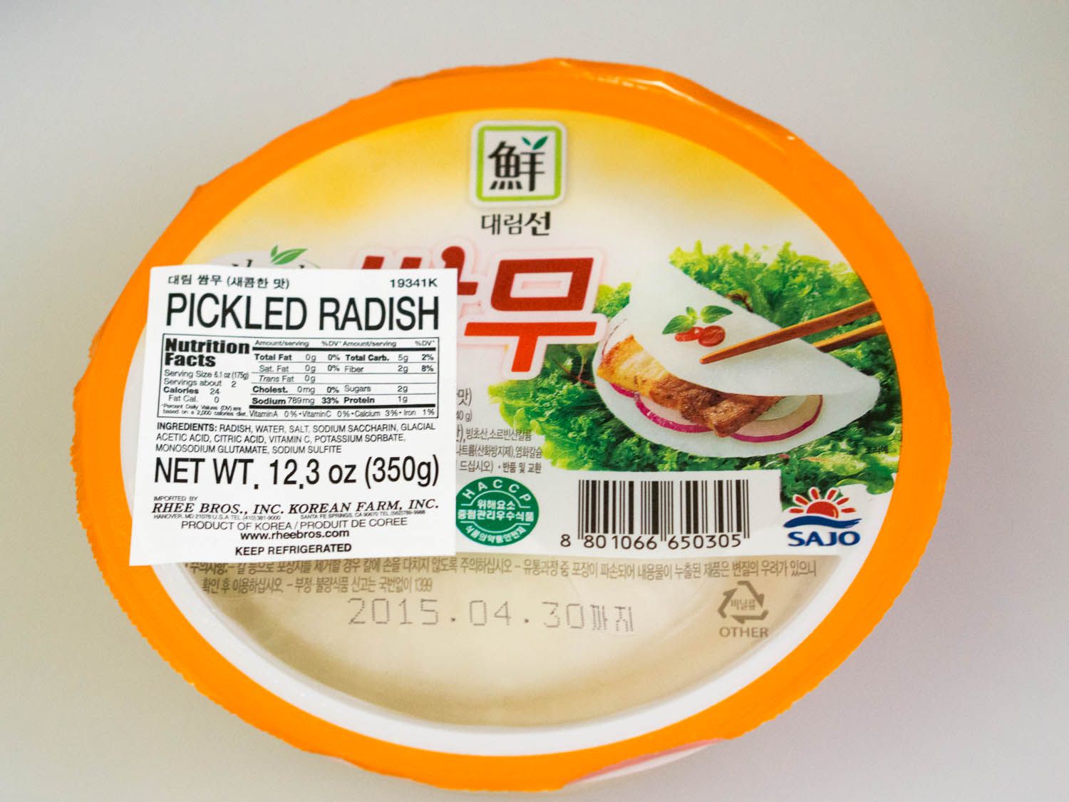 A plastic container of pickled radish slices.