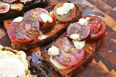 Two Tomato, Alli-oli, and Chive Tartines, assembled on a cutting board.