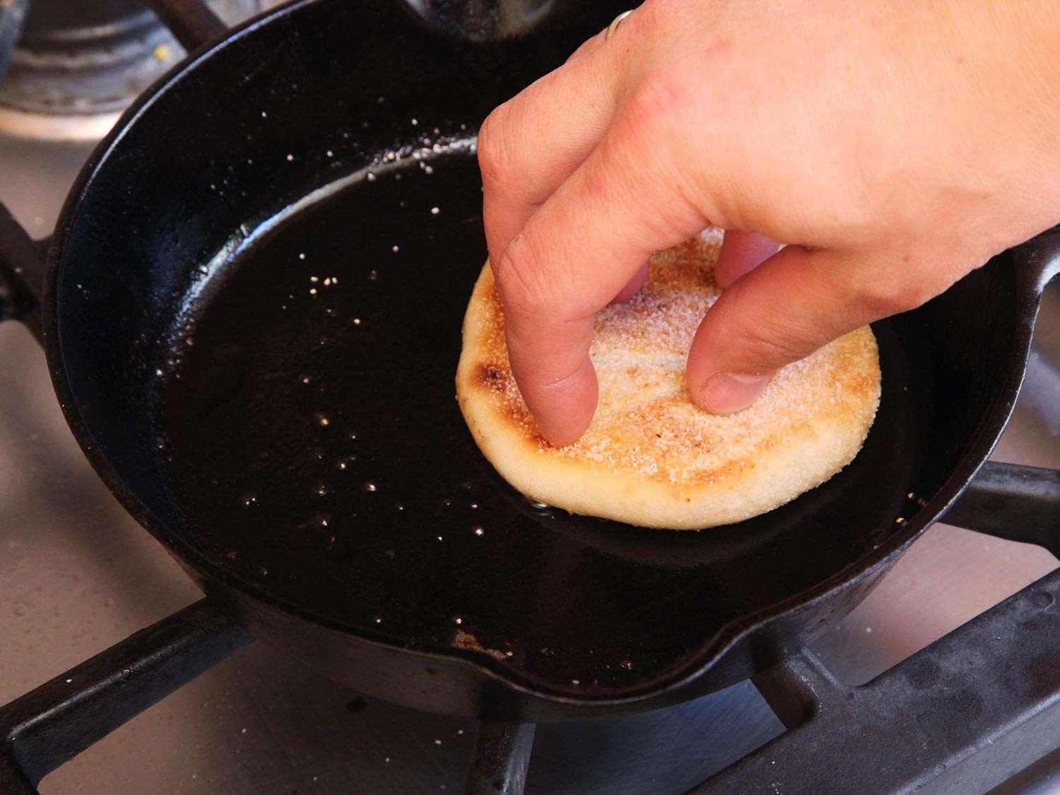 Pressing down the English muffin while it toasts for a homemade Egg McMuffin