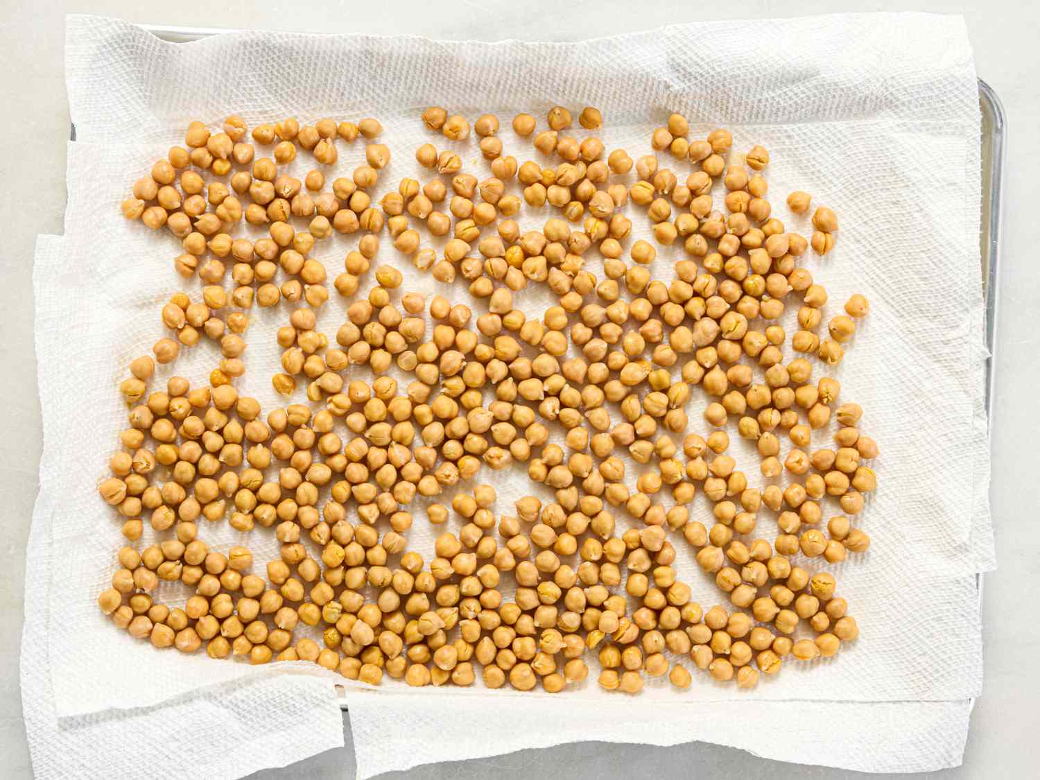 Tray of chickpeas laid out to dry on paper towels