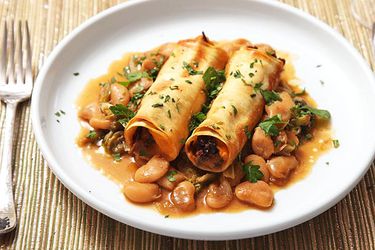 A plate of Sweet Potato and Mushroom Cannelloni, served atop Braised Escarole and Butter Beans.