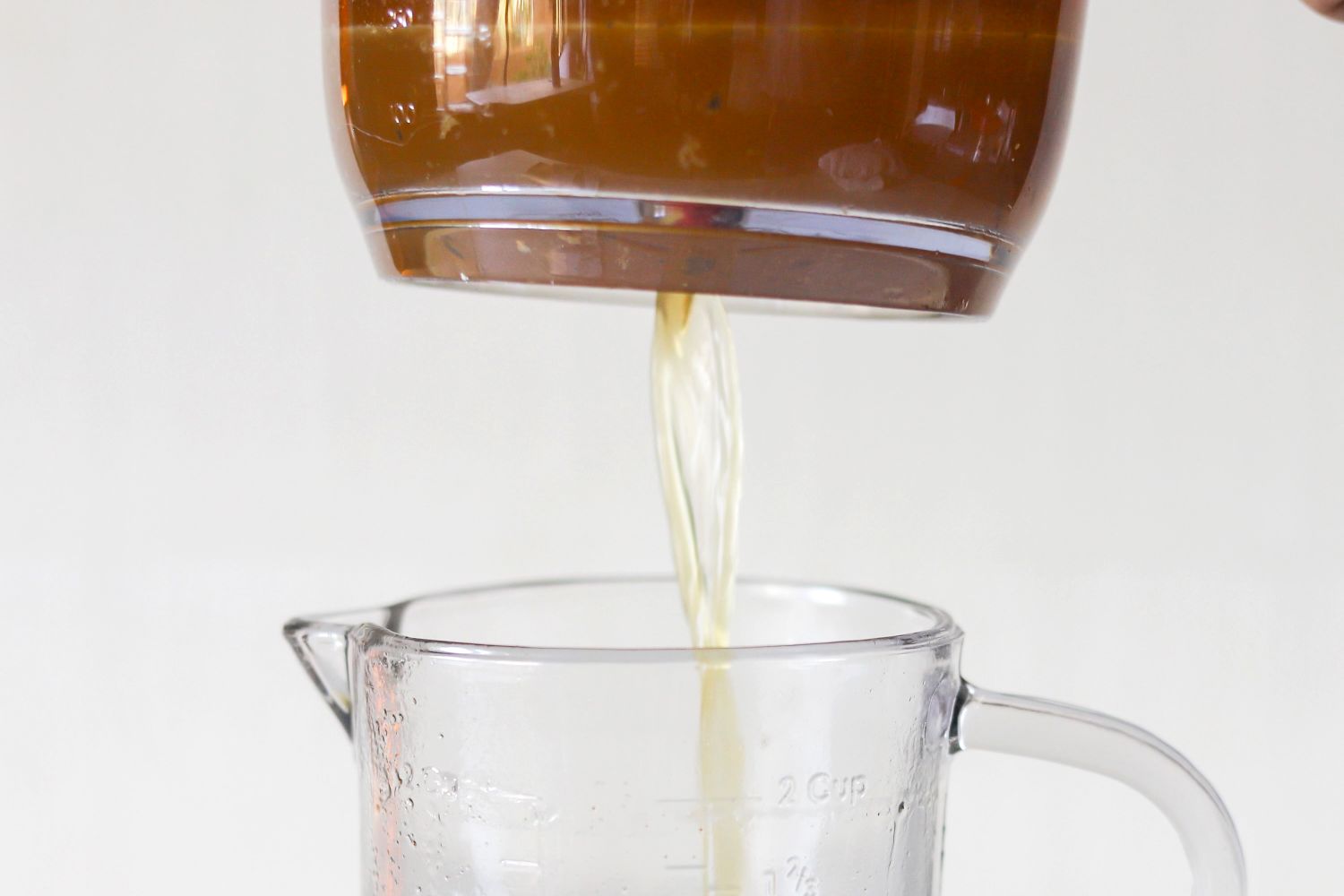 Liquid being poured from a container into a measuring cup