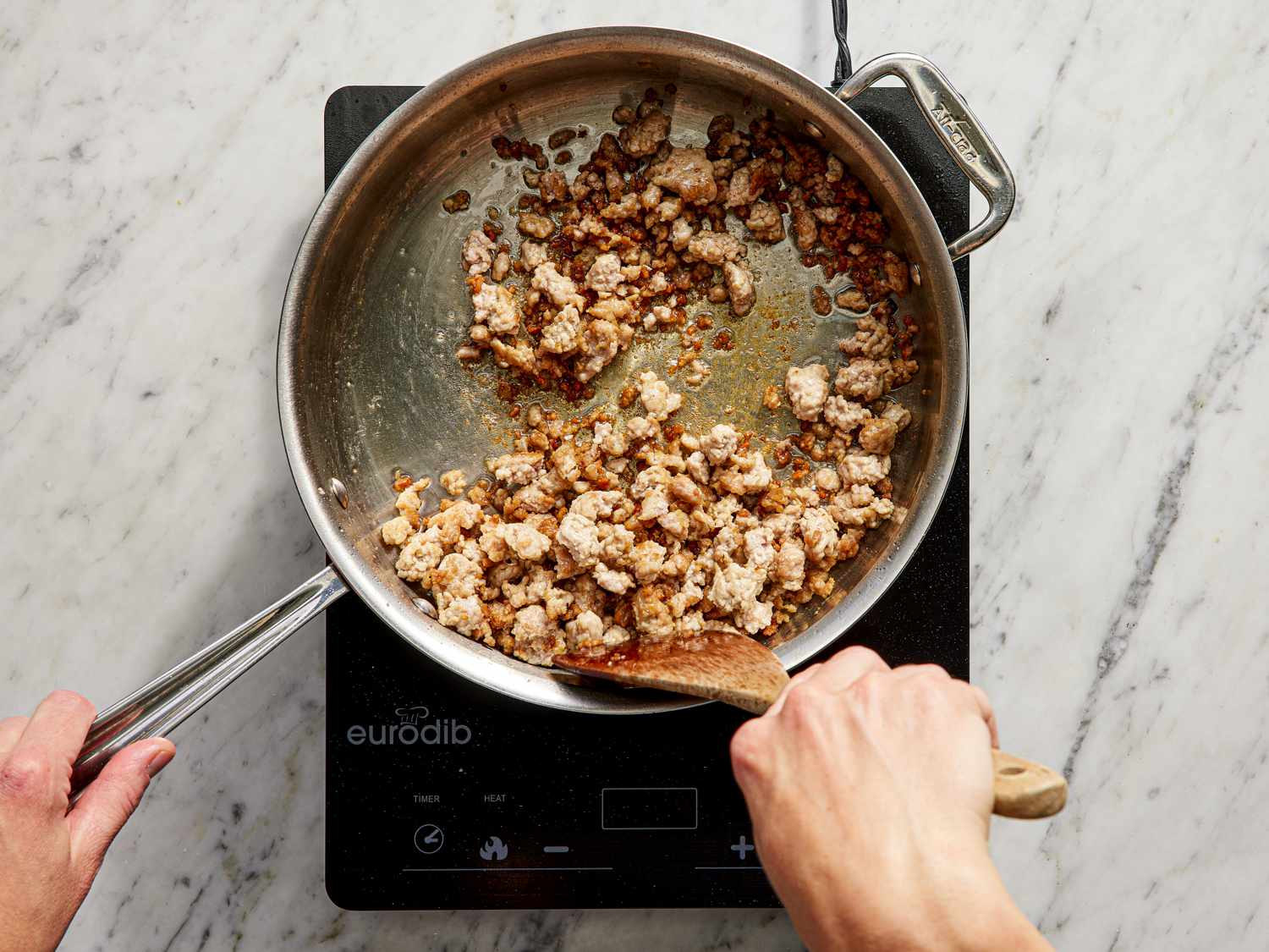 Pork being added to shallots in pot