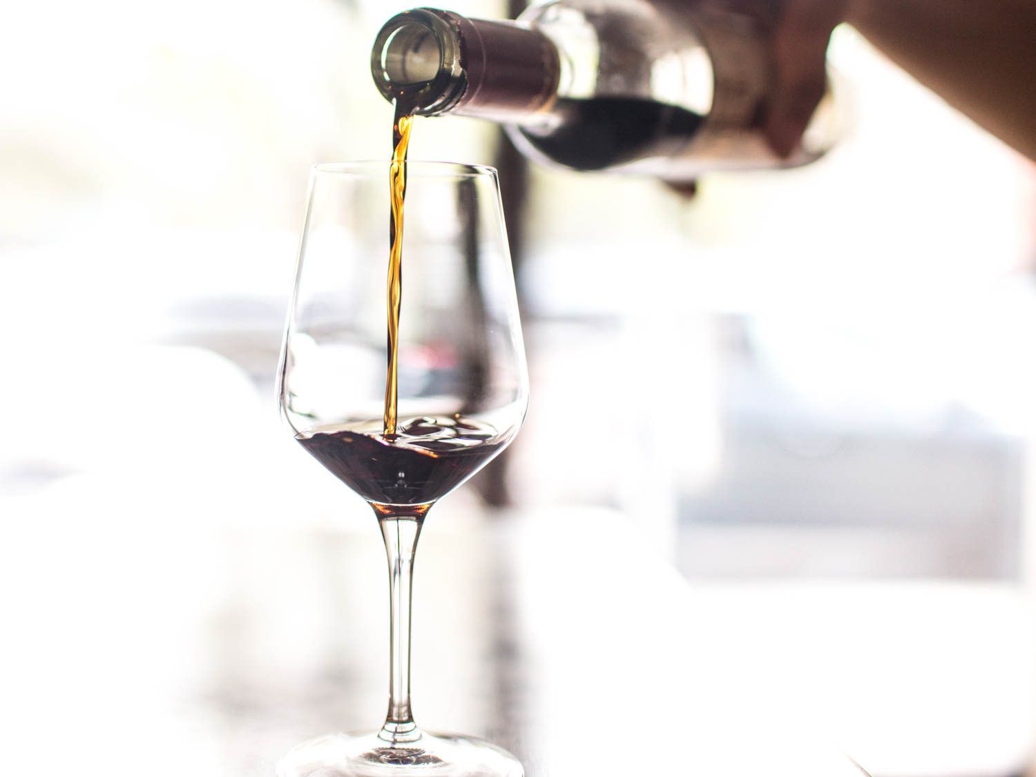 A dark Pedro Ximénez sherry being poured into a wineglass