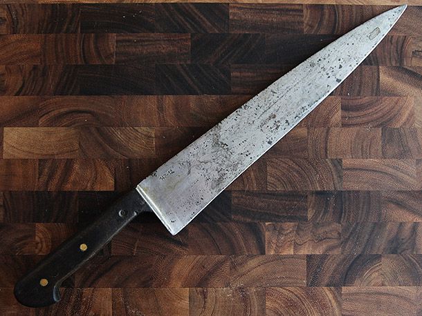 a custom knife on a wooden cutting board