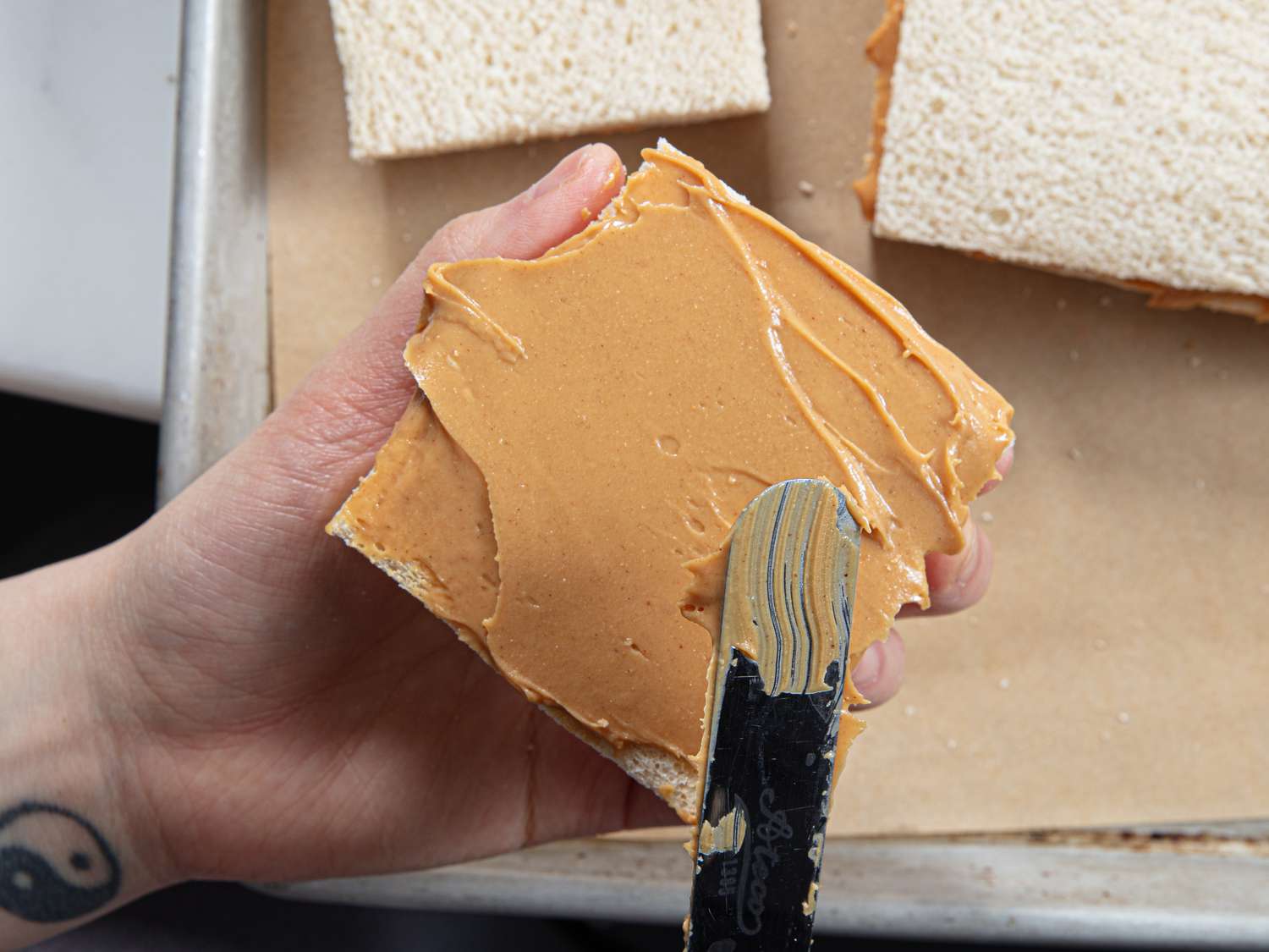 Overhead view of adding peanut butter to bread
